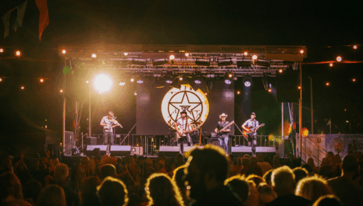 Crowds watch the main stage at Festival of Sails, enjoying live night summer music.