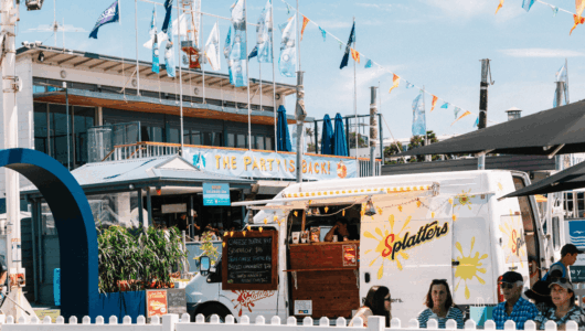 Splatters Cheese Van in front of a Festival of Sails banner at the 2026 event.