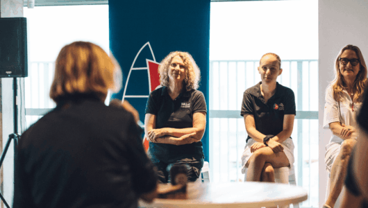 A woman asks a question to the panel at the 2026 SheSails Women on Water Breakfast event.