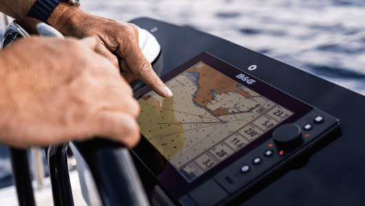 A close up of someone using the touchscreen of the Festival of Sails 2027 early bird prize, a B&G Zeus SR 10” Chartplotter.